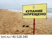 the inscription on the sandy beach - swimming is prohibited. Warning tourists and sunbathers about possible drowning. Black Sea, Anapa, Vityazevo, August 2021, the beach. Sign prohibiting swimming. Редакционное фото, фотограф Юлия Петровская / Фотобанк Лори