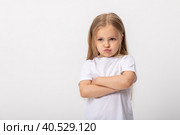Negative human emotions, reactions and feelings. Isolated shot of moody displeased angry little girl crossing arms on her chest, pouting lips, having offended facial expression, being capricious. Стоковое фото, фотограф Ирина Михайличенко / Фотобанк Лори