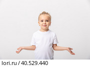 Confused doubtful shocked little girl shrugging feel baffled looking at camera on white blank studio background, cute child puzzled stunned. I dont know concept. Стоковое фото, фотограф Ирина Михайличенко / Фотобанк Лори
