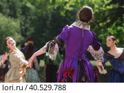 Reconstruction of the court ball of the mid-18th century of Her Imperial Majesty Catherine II in the Tsaritsyno Park in Moscow. Girls in ball gowns dance in the fresh air. (2023 год). Редакционное фото, фотограф Photojuli / Фотобанк Лори
