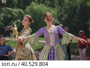 Reconstruction of the court ball of the mid-18th century of Her Imperial Majesty Catherine II in the Tsaritsyno Park in Moscow. Girls in ball gowns dance in the fresh air. (2023 год). Редакционное фото, фотограф Photojuli / Фотобанк Лори