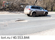 Large pothole an example of poor road maintenance. Стоковое фото, фотограф FotograFF / Фотобанк Лори