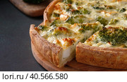 Zoom in video of sliced traditional french open quiche pie with feta cheese and broccoli on dark green background. Стоковое видео, видеограф Мария Зубарева / Фотобанк Лори