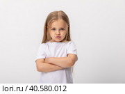 Negative human emotions, reactions and feelings. Isolated shot of moody displeased angry little girl crossing arms on her chest, pouting lips, having offended facial expression, being capricious. Стоковое фото, фотограф Ирина Михайличенко / Фотобанк Лори
