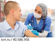 Doctor in a protective mask injects a vaccine to a man with syringe. Стоковое фото, фотограф Яков Филимонов / Фотобанк Лори