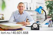 Smiling successful businessman sitting at workplace in office. Стоковое фото, фотограф Яков Филимонов / Фотобанк Лори