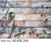 Wrenches and fasteners are located around the wooden background. Empty space for text. Background with tools for business, industry, shops. Стоковое фото, фотограф Бузмакова Светлана / Фотобанк Лори