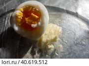 Boiled peeled bitten egg with a piece of butter on a transparent plate/ Очищенное вареное надкусанное яйцо с куском масла. Стоковое фото, фотограф Iva Noel / Фотобанк Лори
