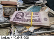 Пачка советских банкнот лежит на старых фотографиях/ Old photographs, a stack of banknotes tied with a rubber band and a vintage alarm clock. Стоковое фото, фотограф Iva Noel / Фотобанк Лори