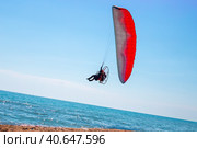 A man on a motor paraglider in the blue sky over the sea, the slope of the horizon. Sports and passion for flying. Стоковое фото, фотограф Коханова Наталья / Фотобанк Лори