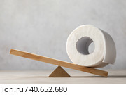 Toilet paper roll on wooden swing or scales on abstract background, template for designer. Стоковое фото, фотограф Сергей Чайко / Фотобанк Лори
