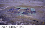 Part of wall of house floats near shore, floating debris has reached Black Sea beaches in Odessa, Ukraine. Environmental disaster caused by explosion of Kakhovka Hydroelectric Power Plant dam, closeup. Стоковое фото, фотограф Некрасов Андрей / Фотобанк Лори