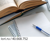Opened books and notebooks are on the table. A pen lies on a blank sheet of a notebook. Background for education, scientific work, libraries. Стоковое фото, фотограф Бузмакова Светлана / Фотобанк Лори