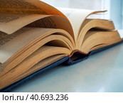 An old thick book with yellow pages is open and lies on the table. Close-up. Background for libraries and education. Стоковое фото, фотограф Бузмакова Светлана / Фотобанк Лори