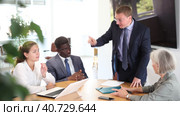 Angry middle-aged man shouting at his business partners sitting around table in conference room. Стоковое видео, видеограф Яков Филимонов / Фотобанк Лори