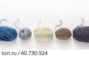 Video of skeins of different types of woolen yarn for hand knitting. Thread ends of different thicknesses and compositions: wool, acrylic, cotton and blends on white background. Flat lay, copy space. Стоковое видео, видеограф Виктория Катьянова / Фотобанк Лори