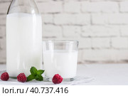 Organic probiotic milk kefir drink or yogurt in glass containers, with raspberry, on the white grey background. Gut health. Probiotic cold fermented dairy drink. Trendy food and drink. Copy space. Стоковое фото, фотограф Tatiana Syrtseva / Фотобанк Лори