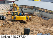 A man is repairing an excavator at a construction site. Стоковое фото, фотограф Юрий Поздников / Фотобанк Лори