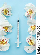 Medical syringe surrounded by white flowers. The concept of beauty injections. Vertical banner. Selective focus. Стоковое фото, фотограф Клара Мухаметзянова / Фотобанк Лори