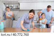 Smiling woman cleaning apartment together with husband and daughters. Стоковое фото, фотограф Яков Филимонов / Фотобанк Лори