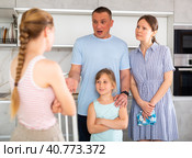 Disgruntled parents reprimanding eldest teenage girl in home kitchen. Стоковое фото, фотограф Яков Филимонов / Фотобанк Лори
