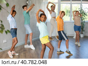 Energetic african american tween girl practicing vigorous dance in group class. Стоковое фото, фотограф Яков Филимонов / Фотобанк Лори