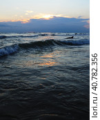 Waves with foam. Beautiful sunset. Foamy waves roll over the sandy shore. Vityazevo, Anapa, Black Sea. Tourist mecca, health resort. Colorful clouds in the evening sky. The rays reflect off the water. Стоковое фото, фотограф Юлия Петровская / Фотобанк Лори