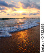 Sunset over sea. Beautiful sunset. Foamy waves roll over the sandy shore. Vityazevo, Anapa, Black Sea. Tourist mecca, health resort. Colorful clouds in the evening sky. The rays reflect off the water. Стоковое фото, фотограф Юлия Петровская / Фотобанк Лори