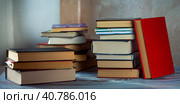 Several stacks of books are on the table. Books are arranged horizontally. One book stands leaning on a pile. Background for libraries, education, science. Стоковое фото, фотограф Бузмакова Светлана / Фотобанк Лори