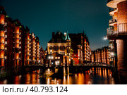 Hamburg, Germany. View of Wandrahmsfleet at dusk in light illumination. Located in Warehouse District -Speicherstadt Landmark of HafenCity quarter. Most visited touristic famous place (2018 год). Стоковое фото, фотограф Igor Tichonow / Фотобанк Лори