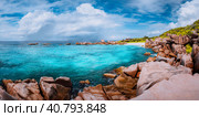 Beautiful panorama with impressive white fluffy clouds wild rocky beach Anse Marron in Seychelles. La Digue. Стоковое фото, фотограф Igor Tichonow / Фотобанк Лори