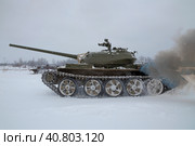 Советский танк Т-54 в движении сумрачным зимним днем. Фрагмент танкового шоу в военно-историческом парке "Стальной десант". Красное Село (2023 год). Редакционное фото, фотограф Виктор Карасев / Фотобанк Лори