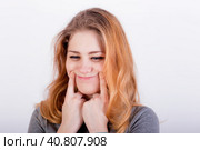 Beautiful young woman forcing a smile, holding her fingers near lips. Стоковое фото, фотограф Сергей Сергеев / Фотобанк Лори