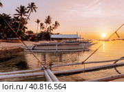 Sunset on the beach with silhouette of banca boat at Panglao Island, Bohol, Philippines (2014 год). Стоковое фото, фотограф Igor Tichonow / Фотобанк Лори