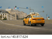Moscow, Russia - July 10, 2022: Yellow taxi at the city street in sunny summer day. Time before the rain. Concept of the lifestyle of the big city. Close up. back. Rear view. Редакционное фото, фотограф YuryKara / Фотобанк Лори