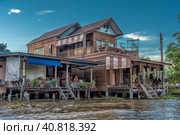 A serene warren of canals, floating houses and stilt houses over the Chao Phraya River, at Krung Thon Bridge (Saphan Sang Hi) (2019 год). Редакционное фото, фотограф Анна Кривицкая / Фотобанк Лори