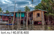 A serene warren of canals, floating houses and stilt houses over the Chao Phraya River, at Krung Thon Bridge (Saphan Sang Hi) (2019 год). Редакционное фото, фотограф Анна Кривицкая / Фотобанк Лори