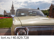 Крупным планом советский автомобиль стоит на Воробьевых горах на фоне высотки МГУ солнечным летним днем в городе Москве, Россия (2023 год). Редакционное фото, фотограф Николай Винокуров / Фотобанк Лори