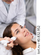 Elderly female beautician doing procedure of microneedling, mesotherapy for young woman in beauty salon indoors. Стоковое фото, фотограф Яков Филимонов / Фотобанк Лори