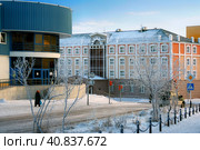 Anadyr, Chukotka, Far East of Russia. Snow-covered street in the city in the far north. Beautiful modern buildings. A pedestrian is walking along the sidewalk. Cold winter weather in the Arctic. Стоковое фото, фотограф Андрей Степанов / Фотобанк Лори