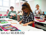 Children 9-10 years old, boys and girls, make homemade crafts at the lesson. Modern standards of education, development of creative abilities and fine motor skills at school April 9, 2022 Serbia Srem. Редакционное фото, фотограф Юлия Петровская / Фотобанк Лори