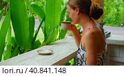 Girl smells and drinking hot morning Balinese coffee enjoying green tropical garden nature. Side view of lonely travel woman in Bali Island Nusa Penida Indonesia. Outdoor. Стоковое фото, фотограф Ольга Сухарева / Фотобанк Лори