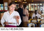 Woman waiter demonstrating her upset with small tip. Стоковое фото, фотограф Яков Филимонов / Фотобанк Лори