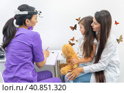 Mom and her infant daughter at the doctor's appointment. Healthy lifestyle concept. The doctor fills out the health questionnaire. Стоковое фото, фотограф Ирина Михайличенко / Фотобанк Лори