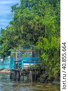 A serene warren of canals, floating houses and stilt houses over the Chao Phraya River, at Krung Thon Bridge (Saphan Sang Hi) (2019 год). Редакционное фото, фотограф Анна Кривицкая / Фотобанк Лори