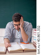 Young male teacher suffering in the classroom. Стоковое фото, фотограф Elnur / Фотобанк Лори