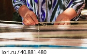 Tashent, Uzbekistan - 4 11 2022: the hand of a weaver weaving a handmade carpet. Редакционное видео, видеограф Aleksey Kidisyuk / Фотобанк Лори