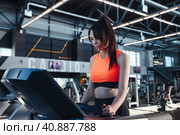 Adult sporty woman workout on treadmill in modern fitness gym. Lady brunette running in interior sports center, exercises treadmill. Cardio working out and sport training concept. Девушка на беговой дорожке в спортзале. Стоковое фото, фотограф Aleksandr Golubev / Фотобанк Лори