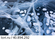 Natural winter blue ice texture with white bubbles and cracks in surface of frozen Baikal Lake in cold February day. Abstract bright textured background, mock up, flat lay, close-up, top view. Стоковое фото, фотограф Виктория Катьянова / Фотобанк Лори