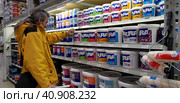 Buyer selects paint and plaster in the store (2018 год). Редакционное фото, фотограф Анна Кривицкая / Фотобанк Лори